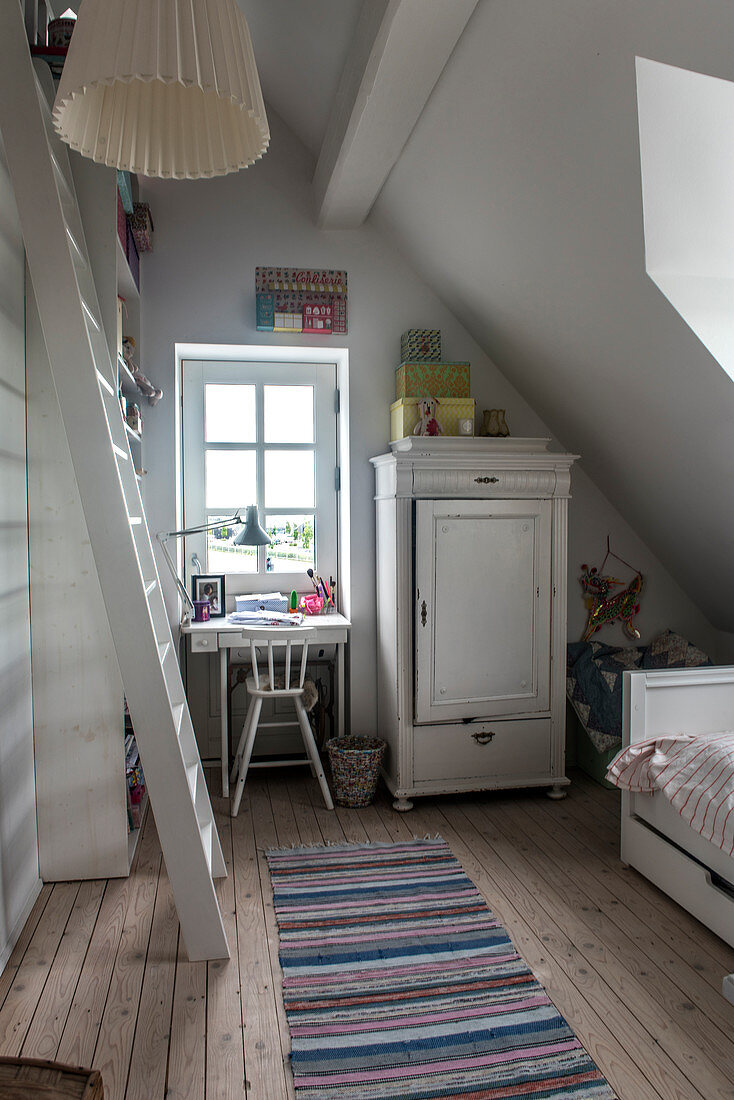 Holzschrank und kleiner Schreibtisch im Mädchenzimmer im Dachgeschoss