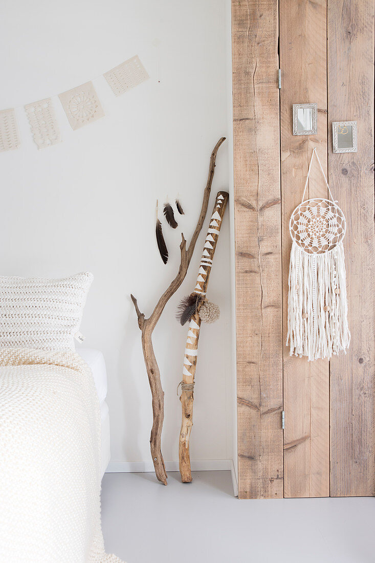 Dream catcher on a wooden wall in white bedroom