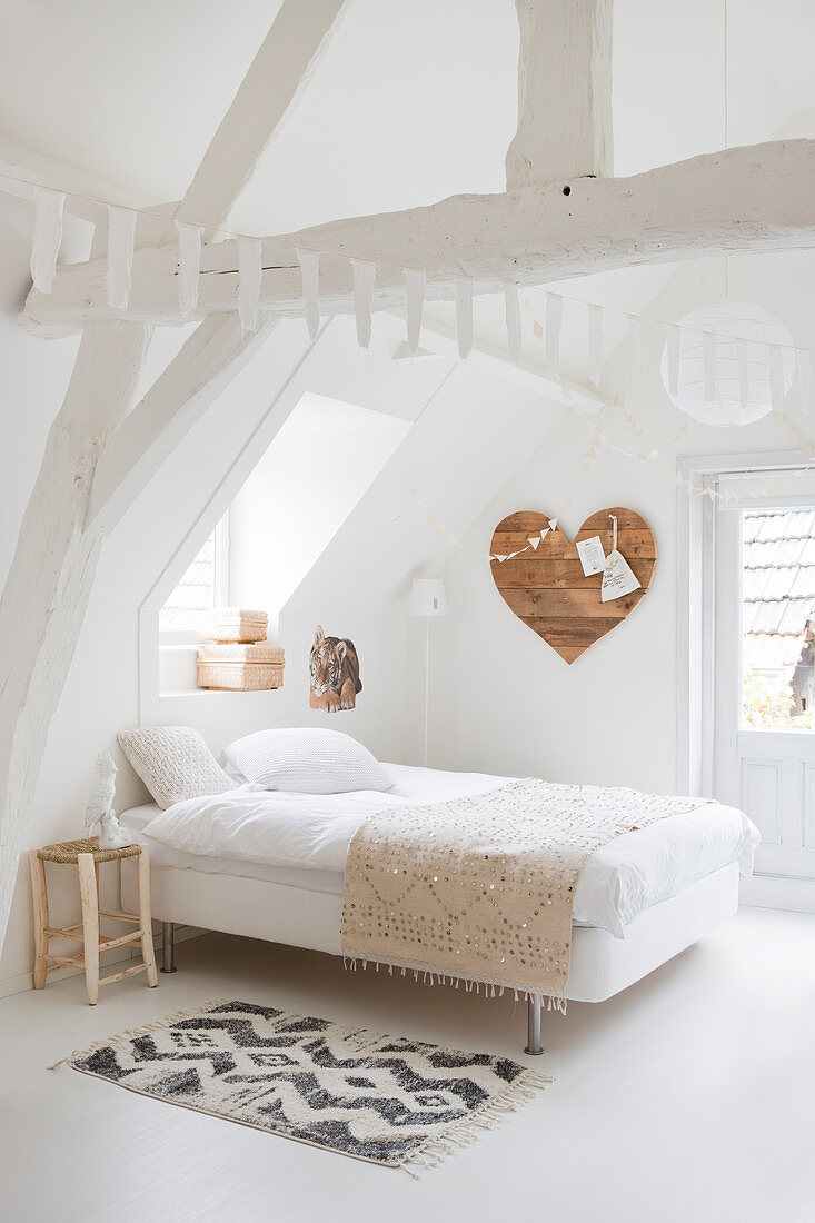 Weißes Schlafzimmer im Dachgeschoß, Herz aus Holz an der Wand