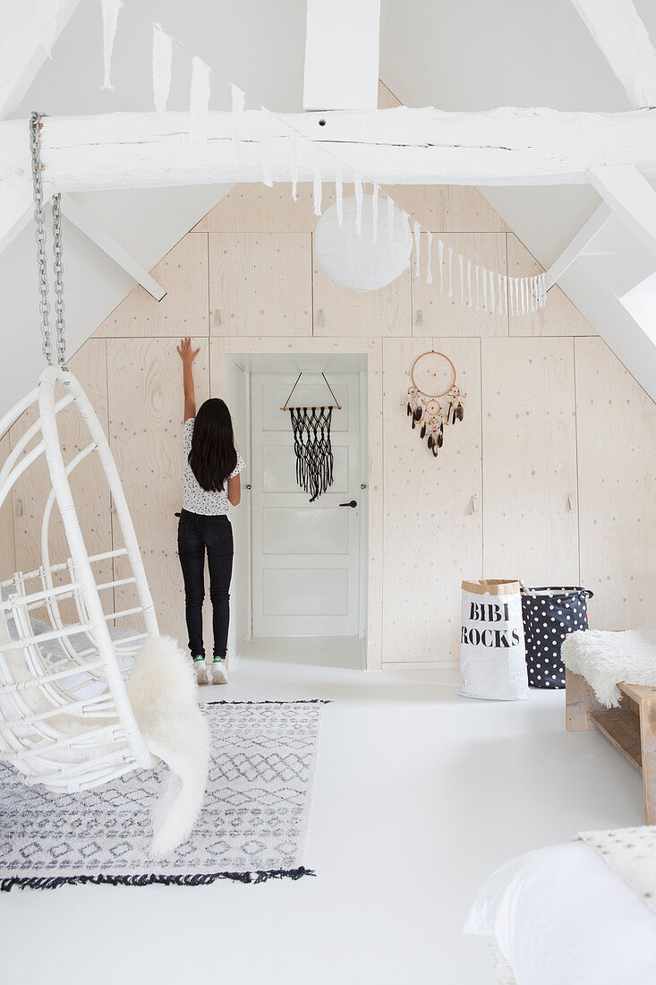 Bright built-in wardrobe and hanging chair in the attic