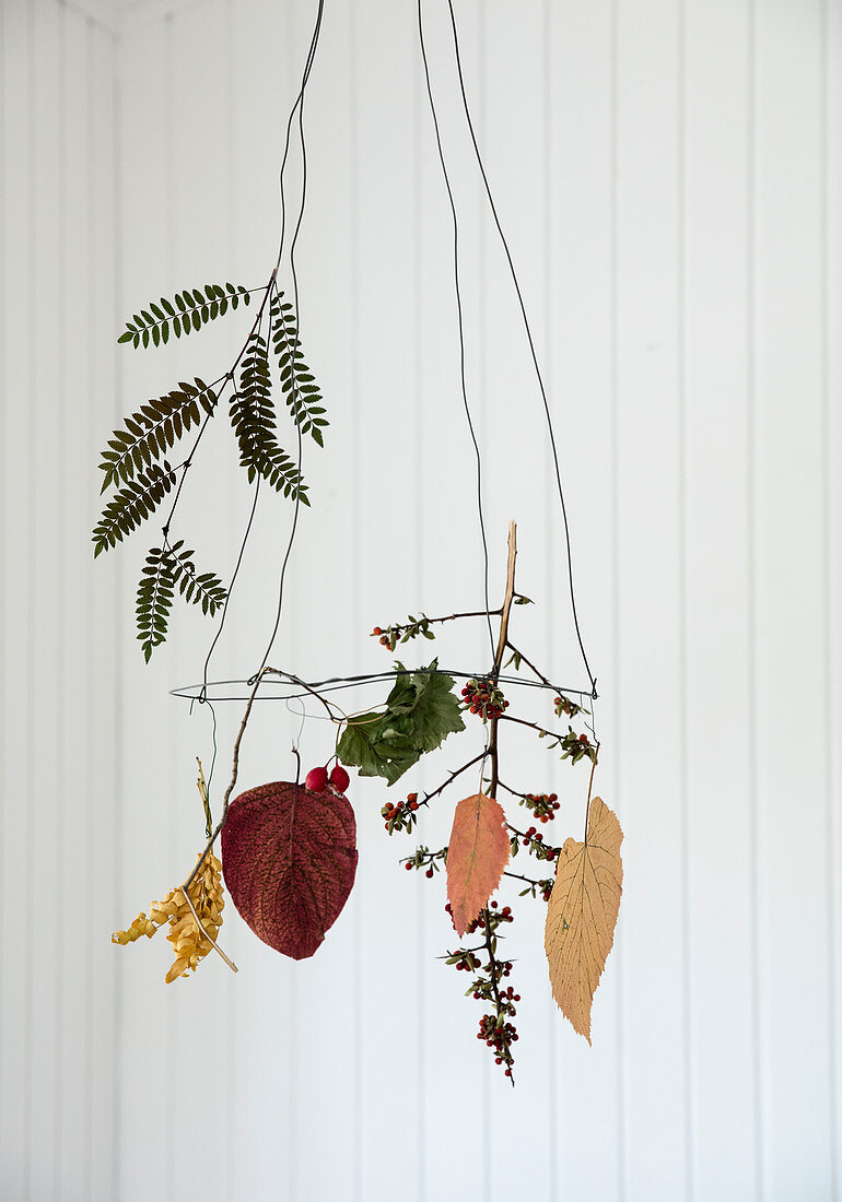 Hanging wreath with pressed leaves, twigs, and dried berries