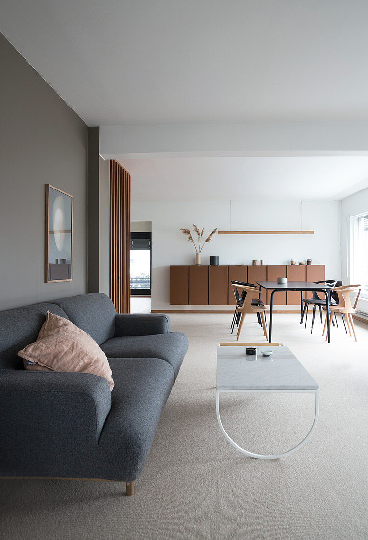 Graues Polstersofa und Couchtisch in minimalistischem Wohnbereich