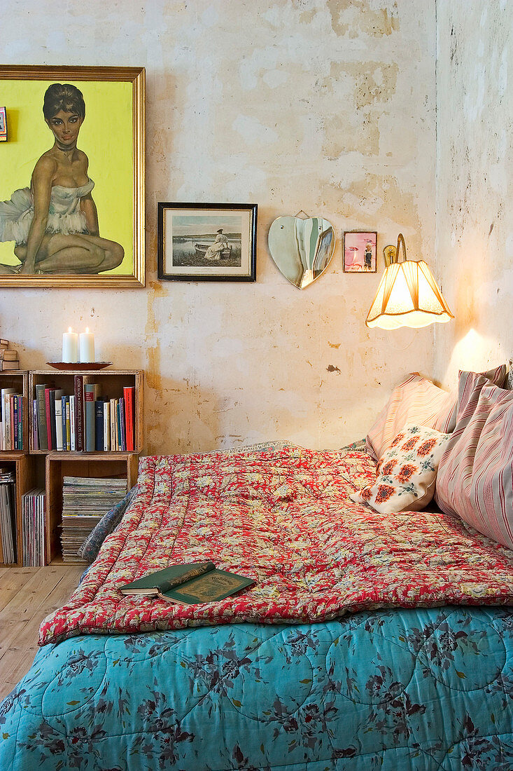 Tagesbett im Wohnraum mit abgenutzten Wänden und Holzkisten als Regal