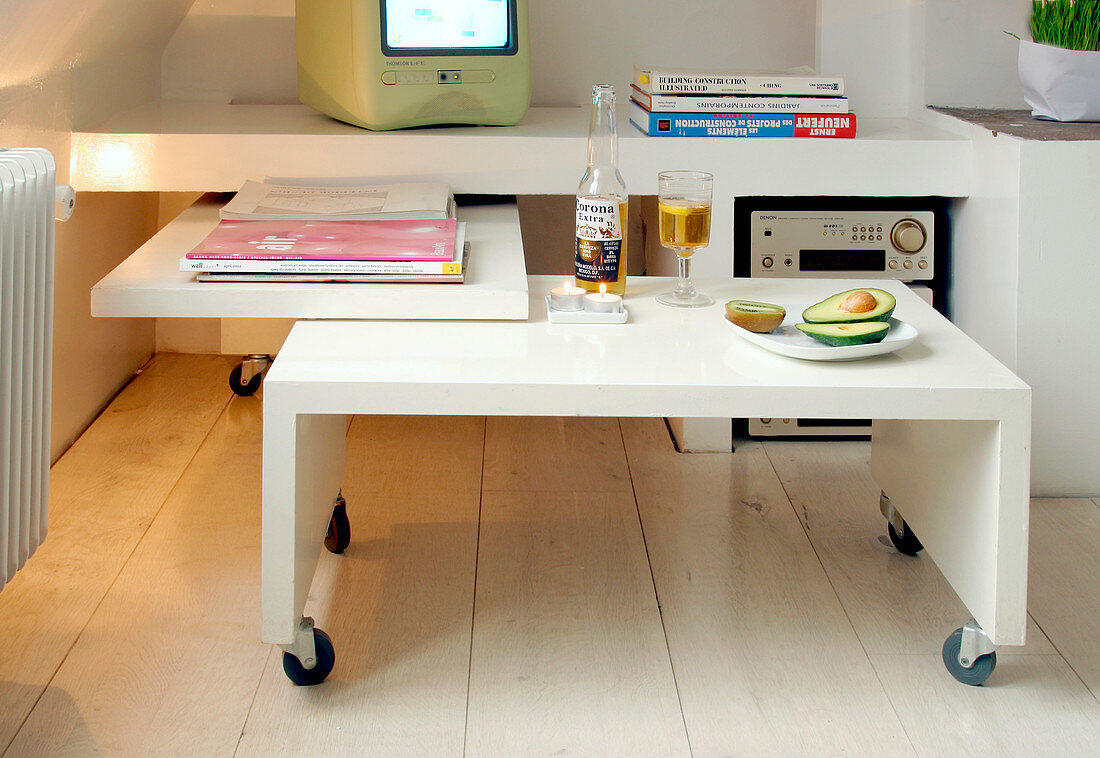 Modern white coffee table on castors fits under the sideboard to save space