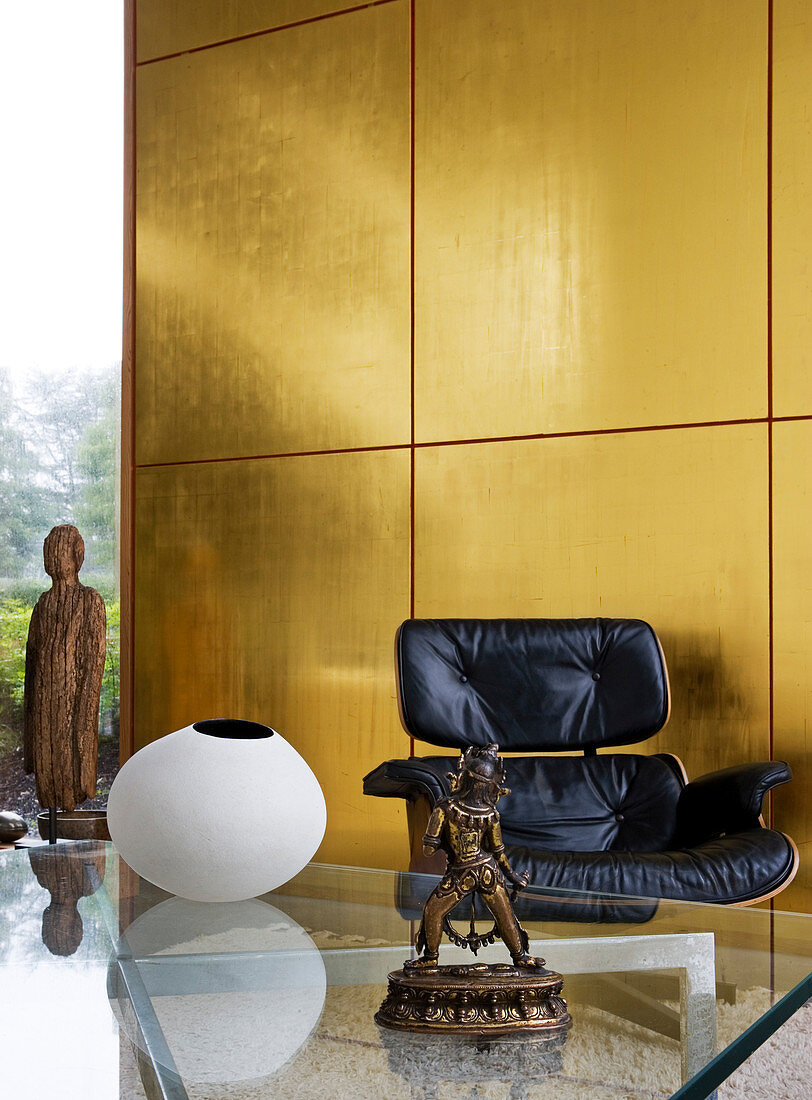 Golden wall panels in a living room with a designer armchair