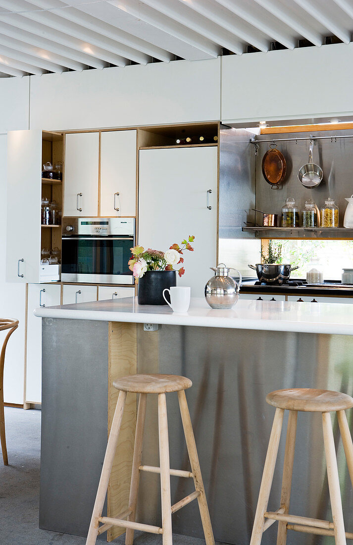 Barhocker an der Kücheninsel mit Edelstahlfront in moderner Küche