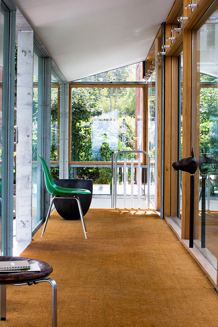 Grüner Stuhl im modernen Flur mit Kokosteppich und Fensterfront