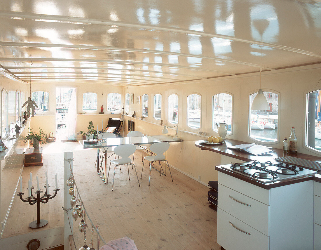 Open kitchen with gas stove and dining table in a houseboat