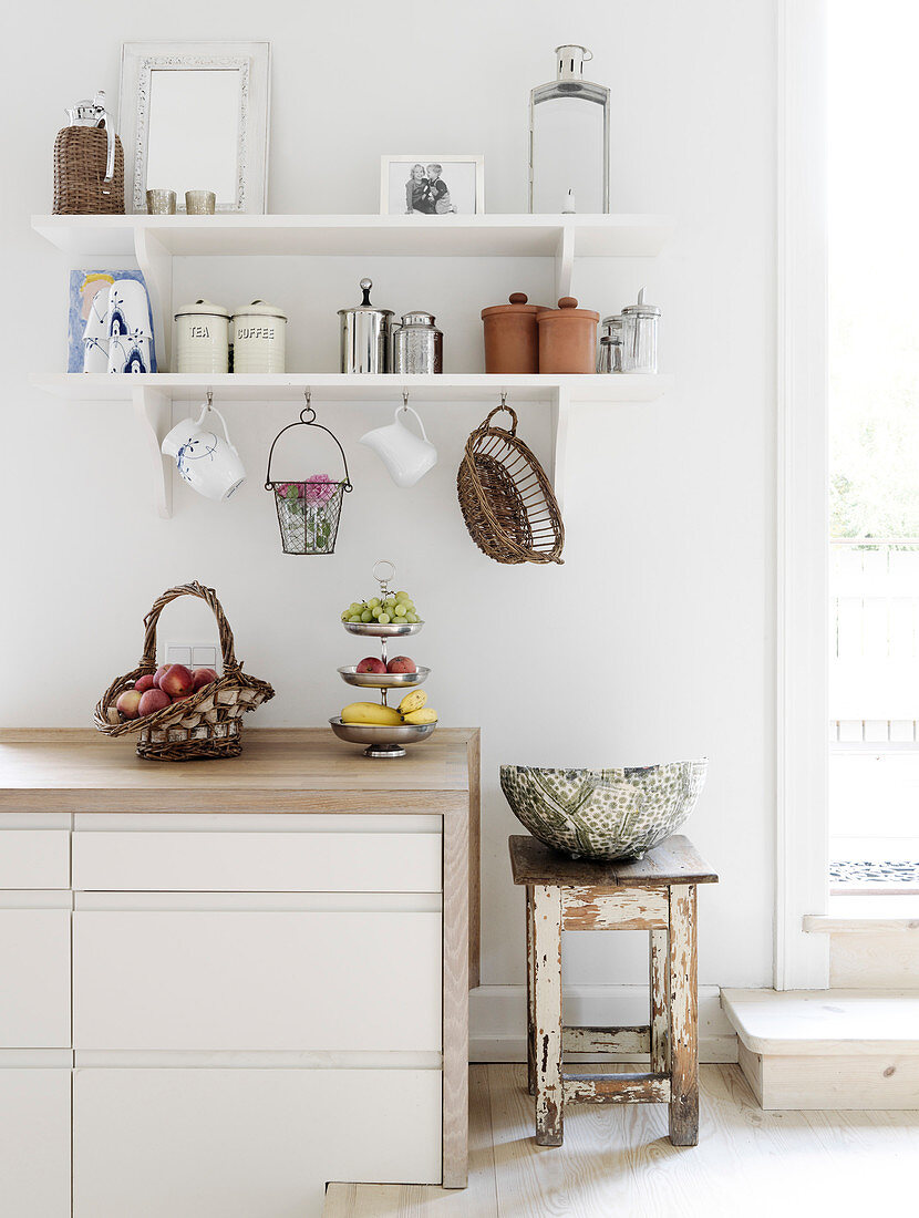 Storage containers on wall shelves in the white kitchen