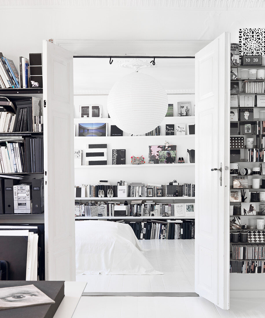 Blick durch offene Doppeltür ins Schlafzimmer mit Bücherregalen