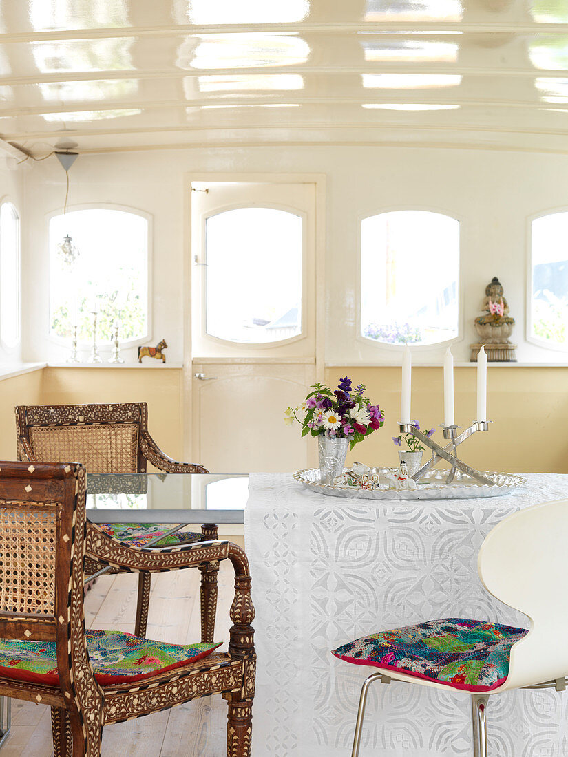 Verschiedene Stühle am Esstisch im Hausboot