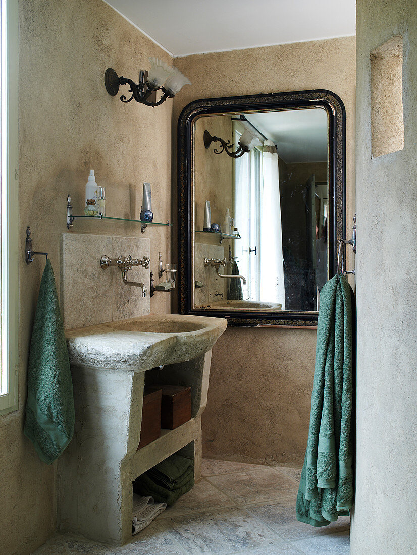 Concrete vanity and wall mirror with antique frame in the bathroom