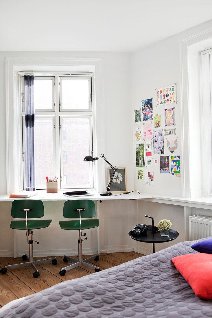 White desk with two vintage swivel chairs in front of a window in the bedroom