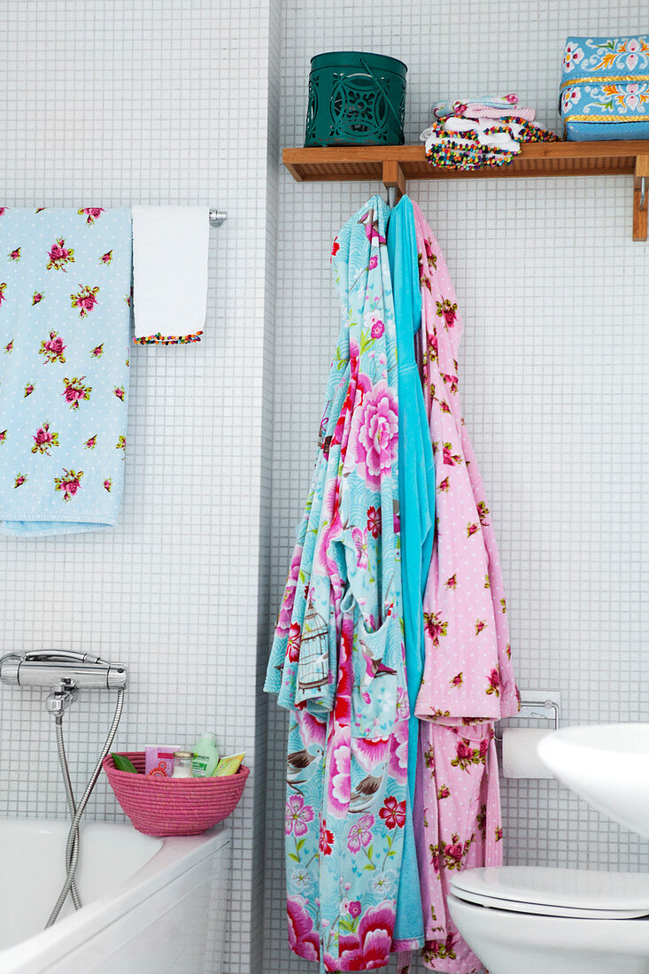 Bunte Bademäntel im Badezimmer mit weißen Mosaikfliesen