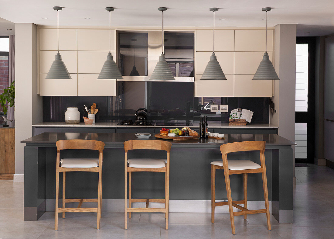 Bar stools at island counter in modern kitchen in shades of grey