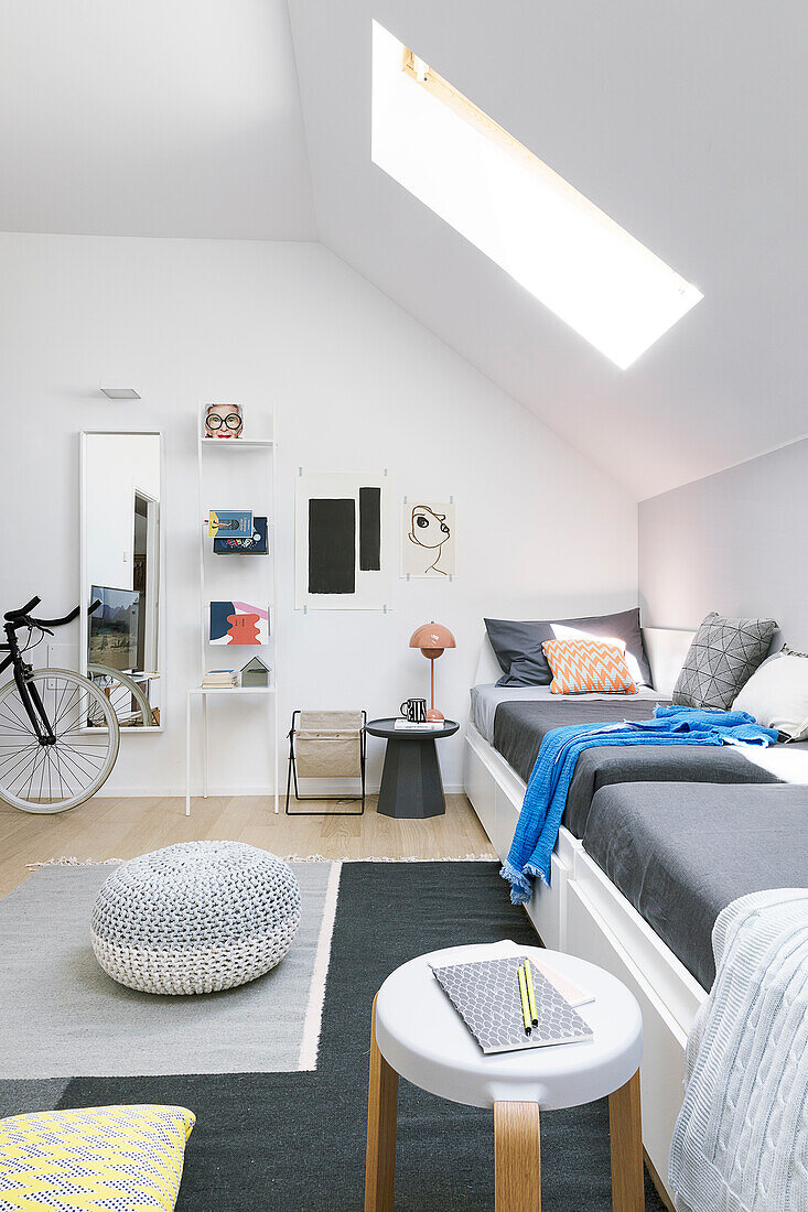 Couch against knee wall below skylight in sloping attic ceiling