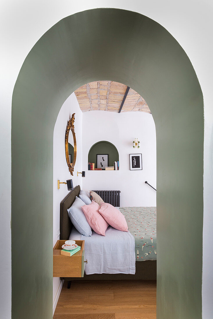 View of double bed through arched doorway