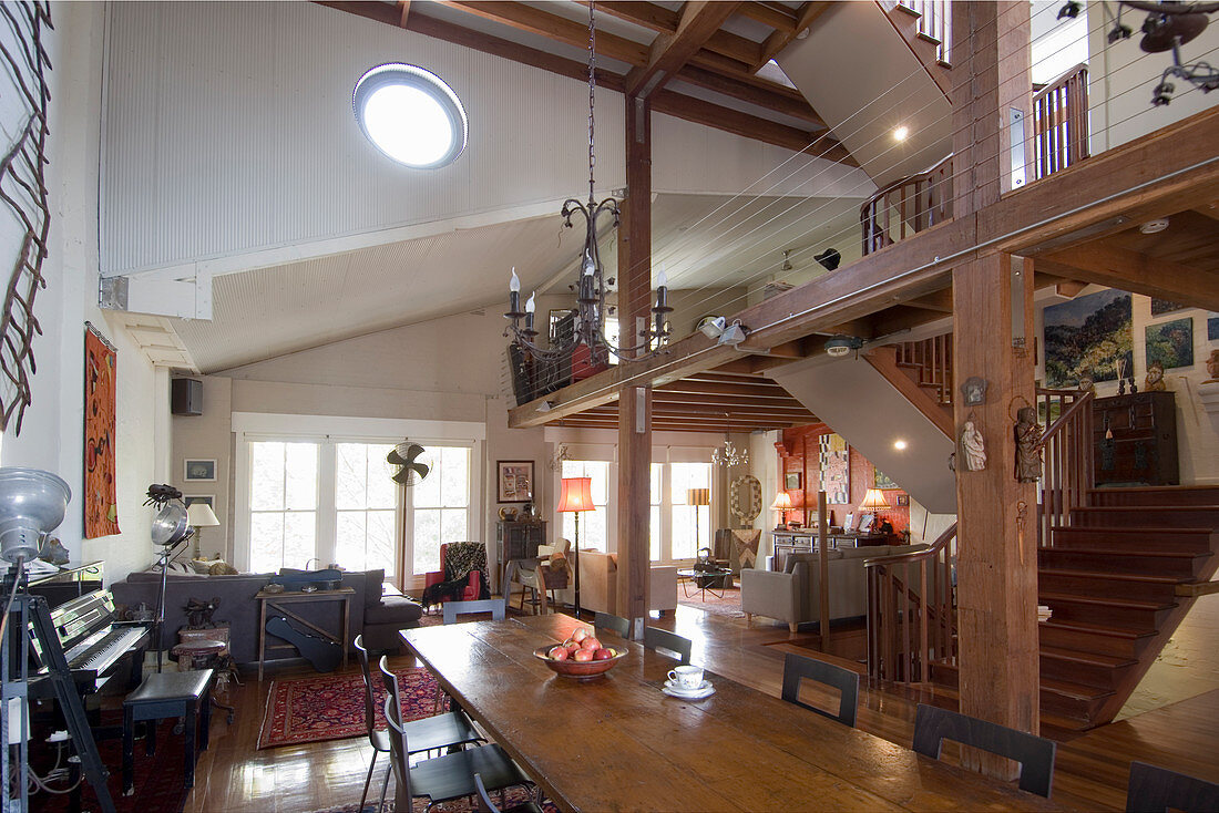 Gallery and wooden beams in open-plan interior on multiple levels