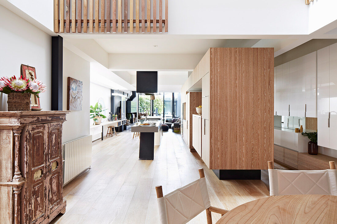 Einbauküche mit Holzfronten und Kochinsel in offenem Wohnraum