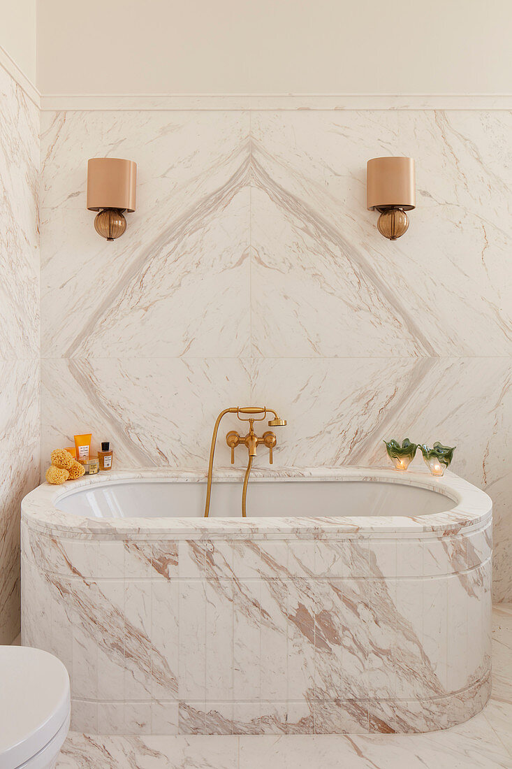 Luxuriöses Badezimmer mit Marmor an Wand und Badewanne