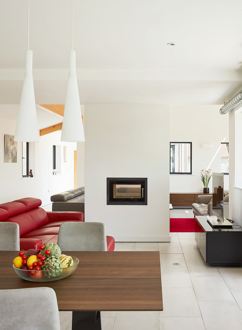 Fireplace in partition wall in modern, open-plan interior