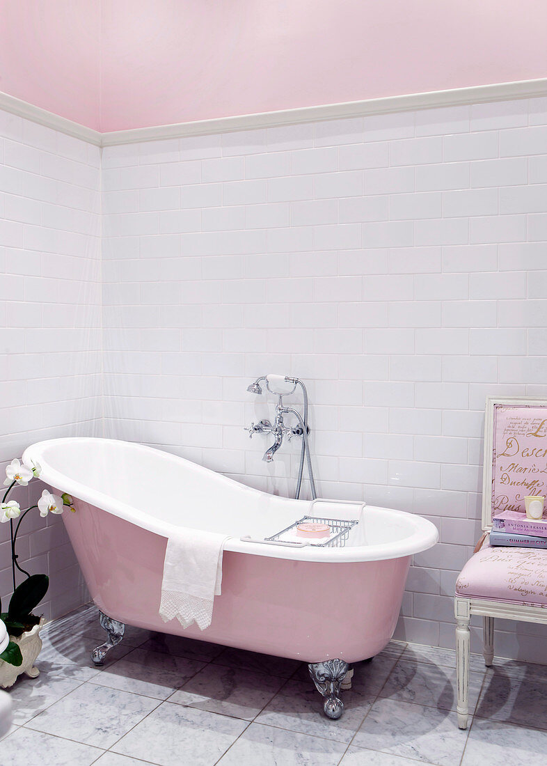 Freestanding pink bathtub in bathroom with historical flair