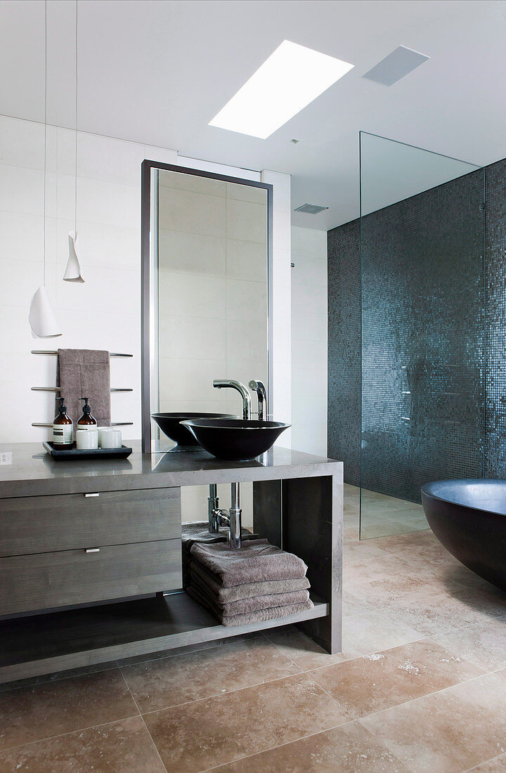 Moderner Waschtisch im Bad in dunklen Naturtönen mit Steinboden