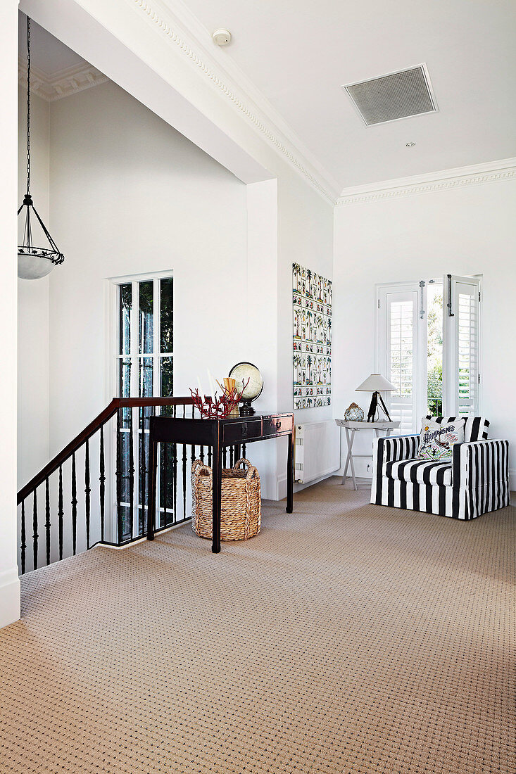 Hallway area with black and white striped armchair and stairway in beach house
