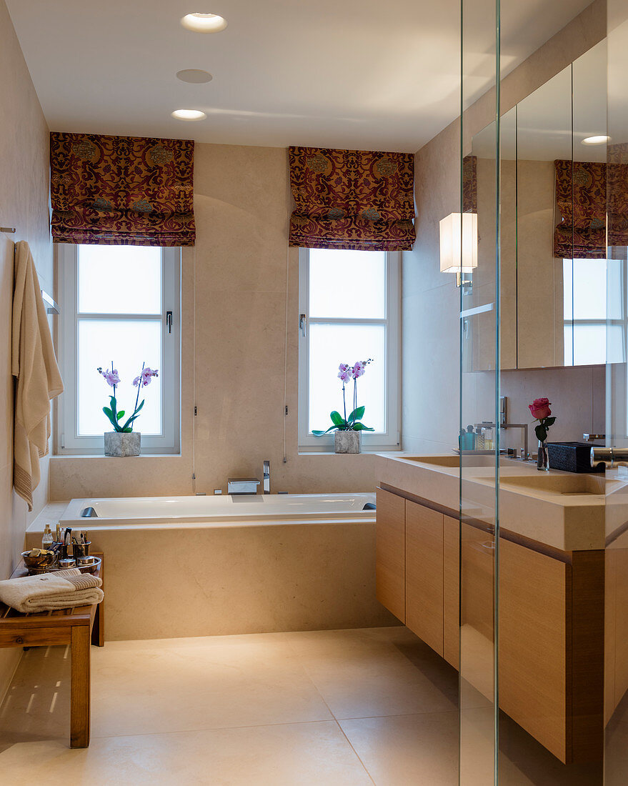 Classic, beige bathroom with twin washstand and bathtub