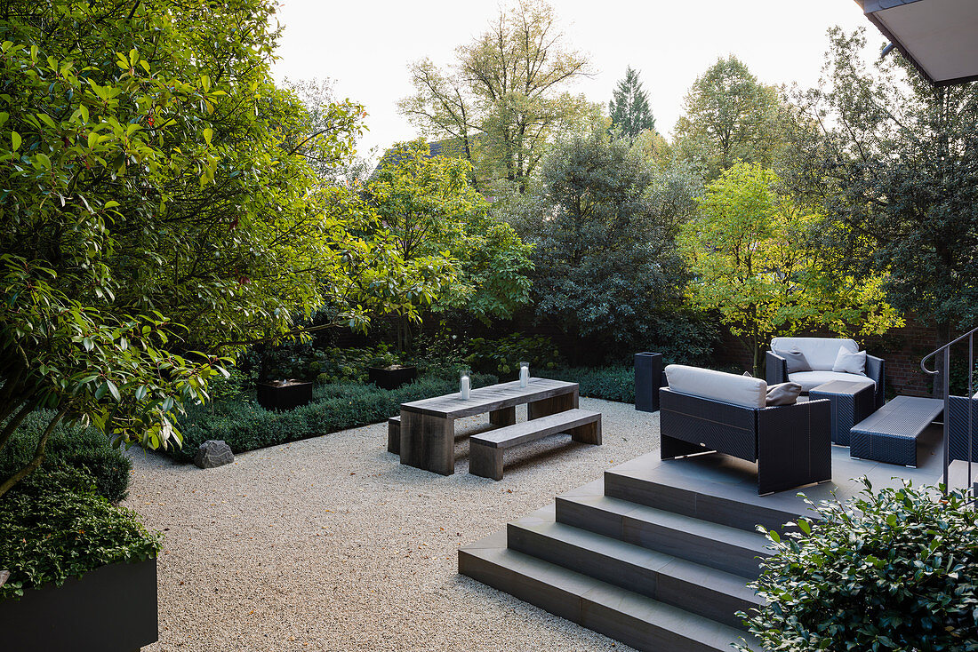 Lounge furniture on terrace in luxurious garden with gravel floor
