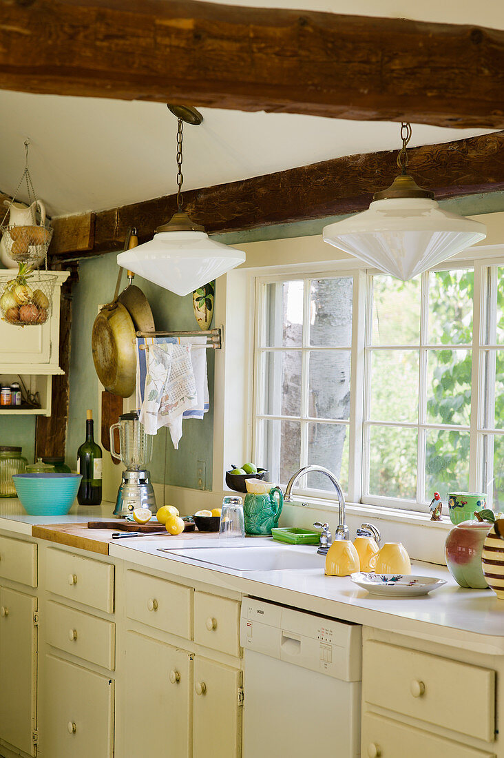 Küche im Landhausstil mit Holzbalken und Sprossenfenster
