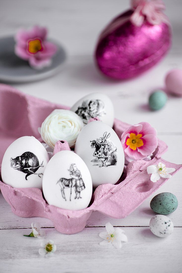 Ostereier mit schwarz-weißen Aufklebern in rosa Eierschachtel