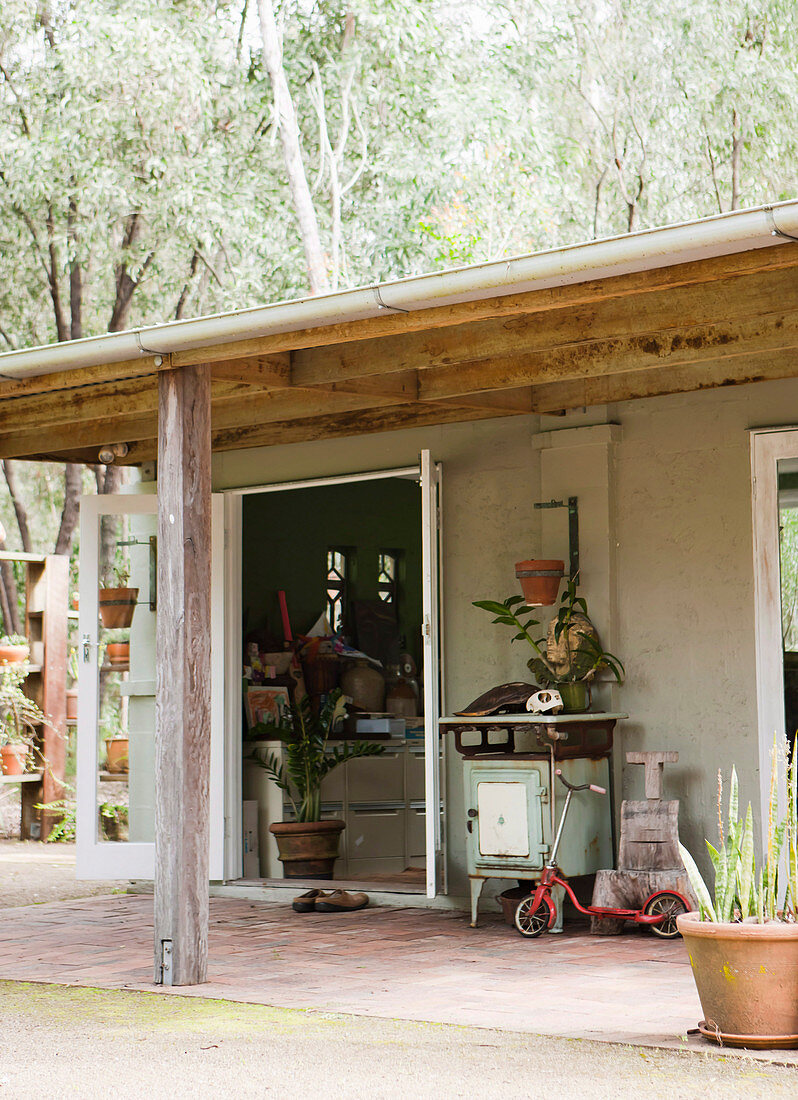 Holzhäuschen im Garten mit Vordach als Schuppen und Arbeitsraum