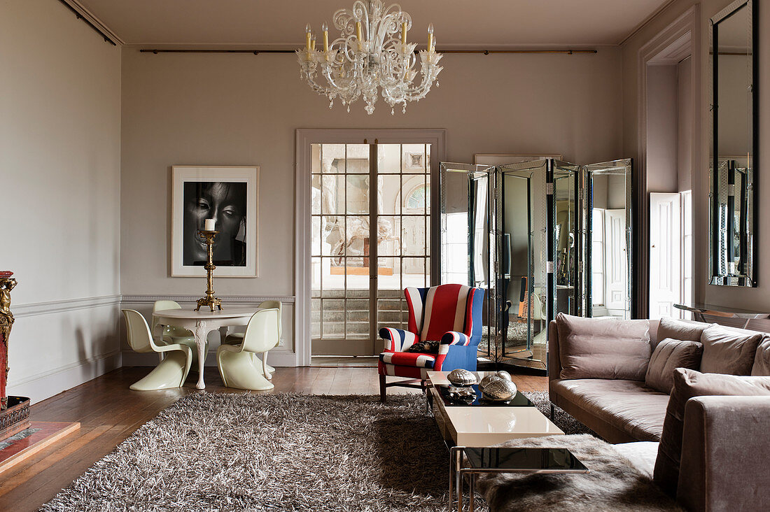 Murano-Kronleuchter im Salon mit Klassikerstühlen, Ohrensessel mit Union Jack-Motiv und Sofa