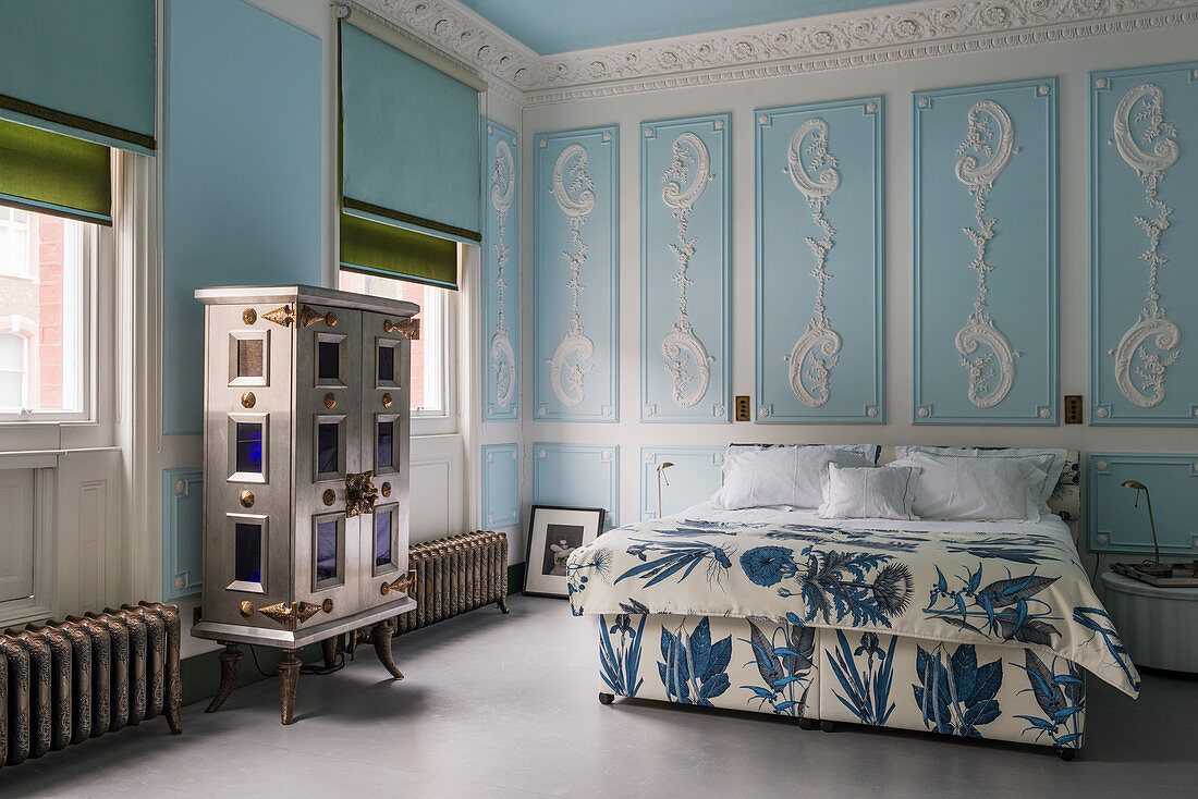 Bedroom with sky-blue walls and ornate stucco elements
