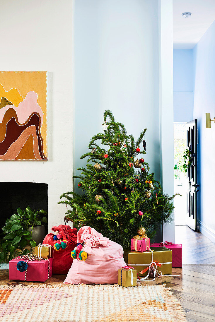 Wohnraum dekoriert mit Christbaum, bunten Nikolaussäcken und verpackten Geschenken