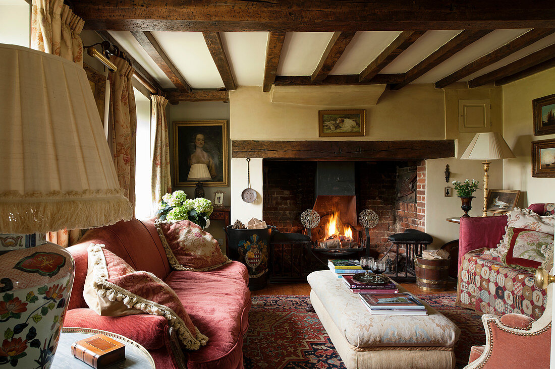 Inglenook fireplace and wood-beamed ceiling in living room of English country house
