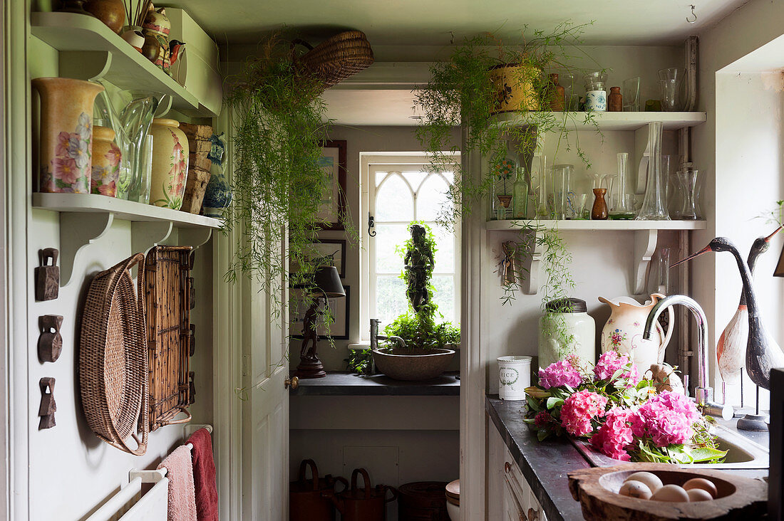 Vasensammlung auf Wandregalen in kleiner Landhausküche