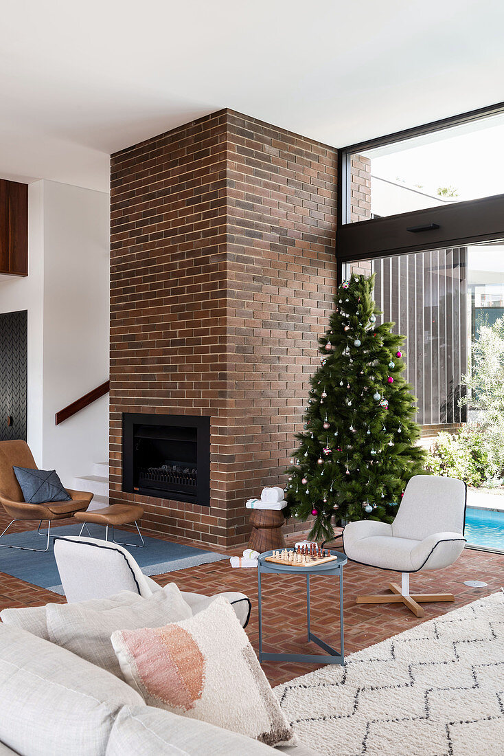 Fireplace in the brick wall in the living room with Christmas tree