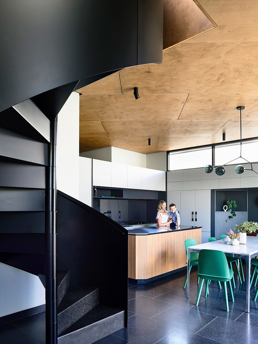 Schwarze Wendeltreppe im Architektenhaus mit offener Küche