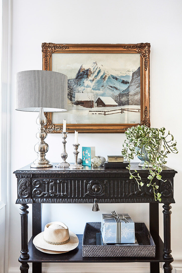 Silver table lamp on black antique console table