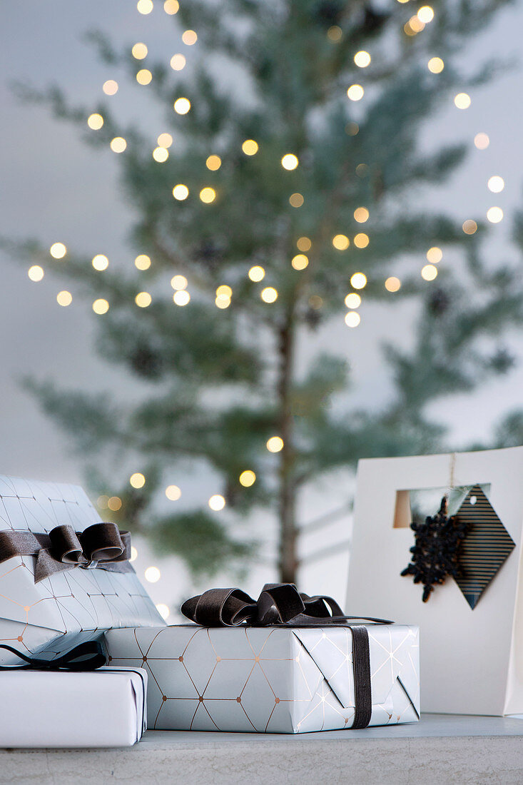 Elegantly wrapped presents in front of the Christmas tree