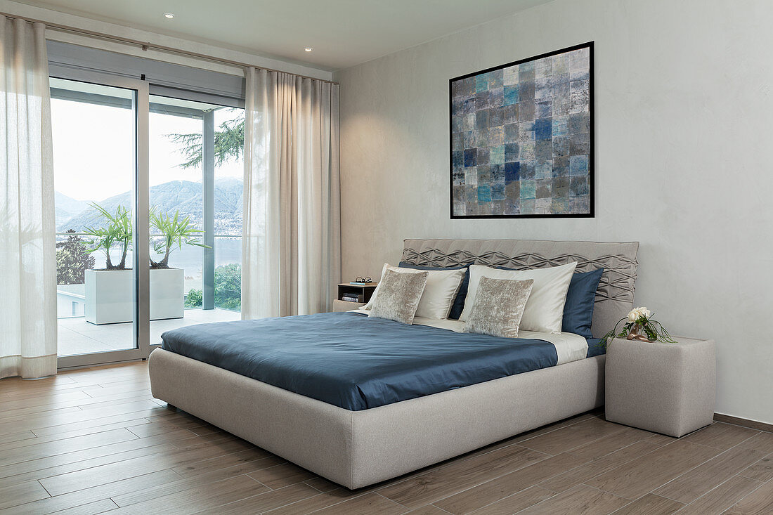 Polsterbett im minimalistischen Schlafzimmer in Grau und Blau