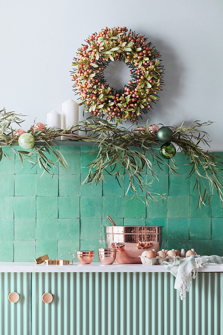 Christmas decoration over green tiles and vanity in the kitchen