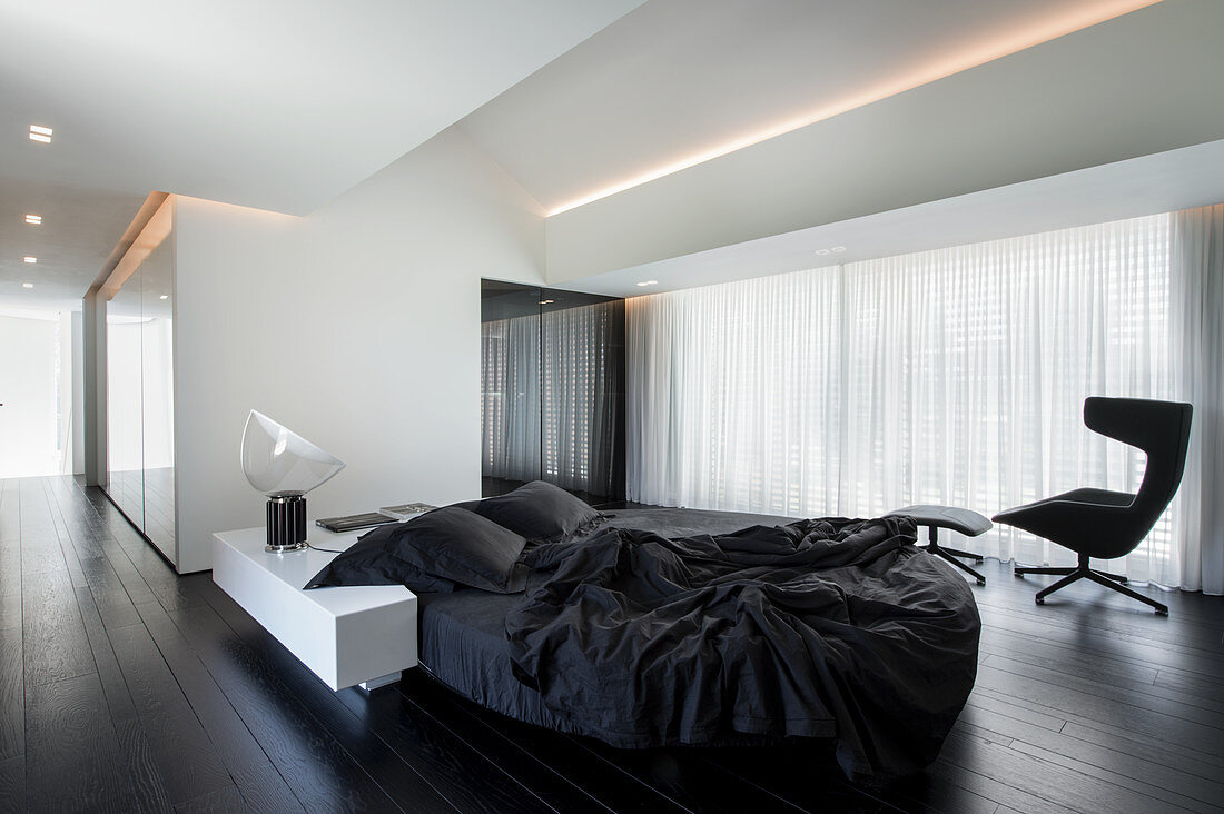 Minimalistischer Schlafraum in Schwarz und Weiß mit Designermöbeln