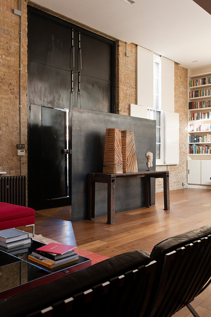 Partition and floor-to-ceiling metal doors in entrance area of loft apartment