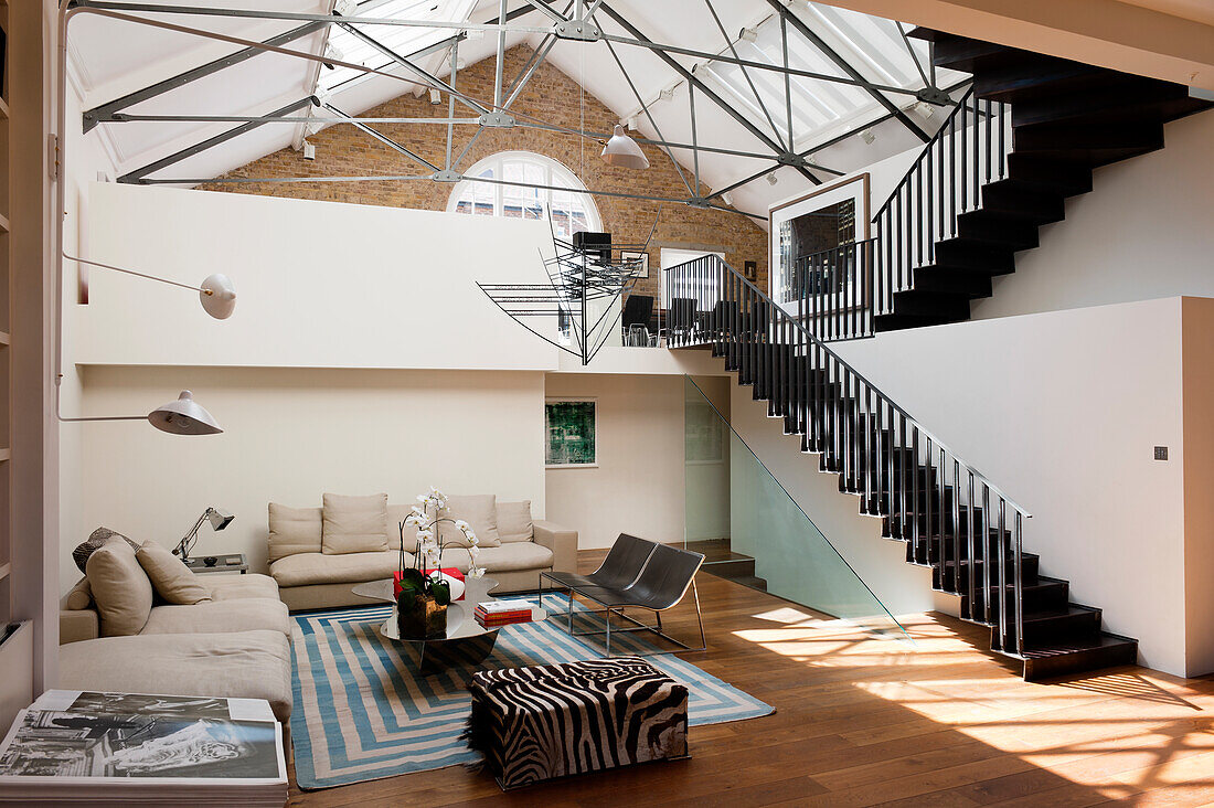 Black steel staircase and wrought iron cross-members in multi-storey loft apartment