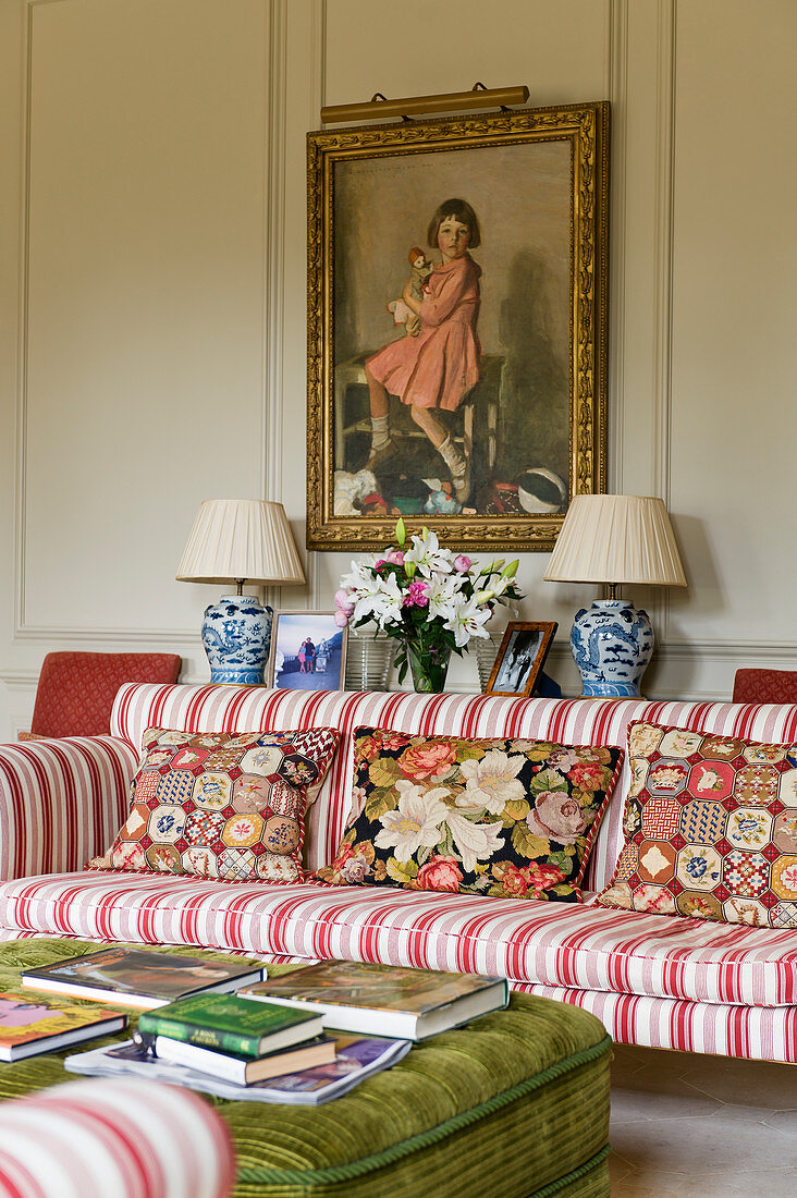 Gestreiftes Sofa mit Gobelin-Kissen darüber historisches Wandgemälde in englischem Herrenhaus