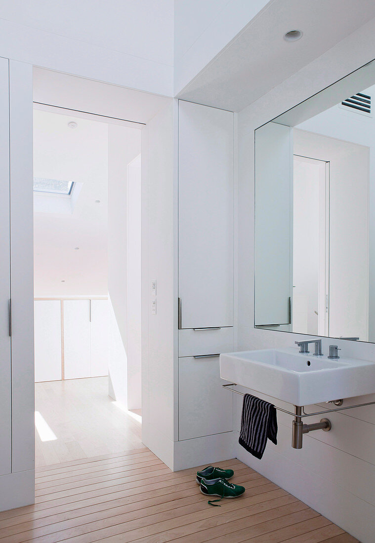 Weißes Badezimmer mit Einbauschrank, Spiegel und Waschbecken