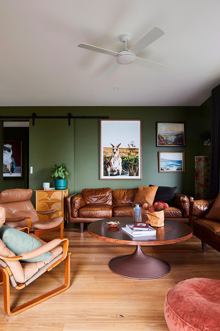 Wohnzimmer in Braun und Grün mit Ledersofas und Ledersesseln
